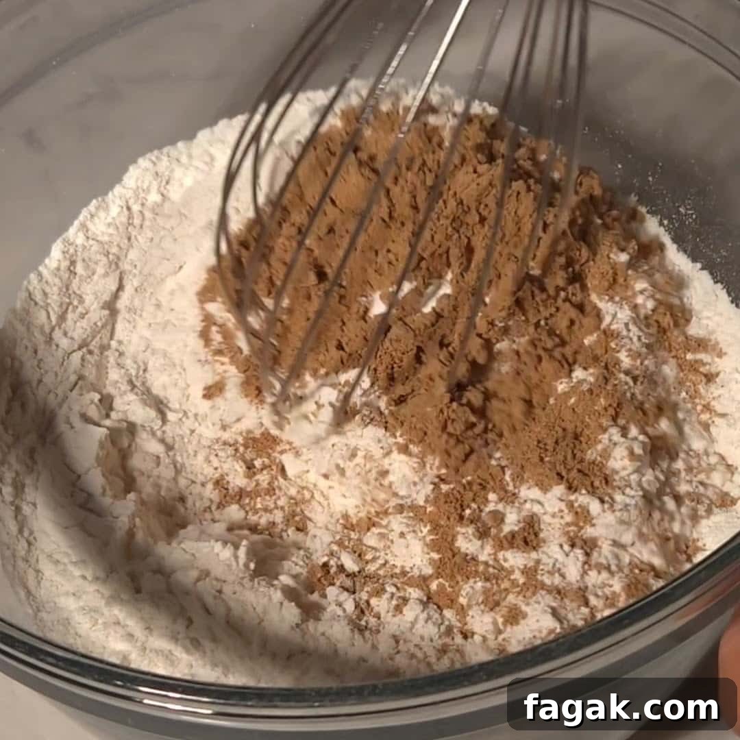 A mixing bowl filled with flour and chai spices, capturing the process of creating the bundt spice cake.