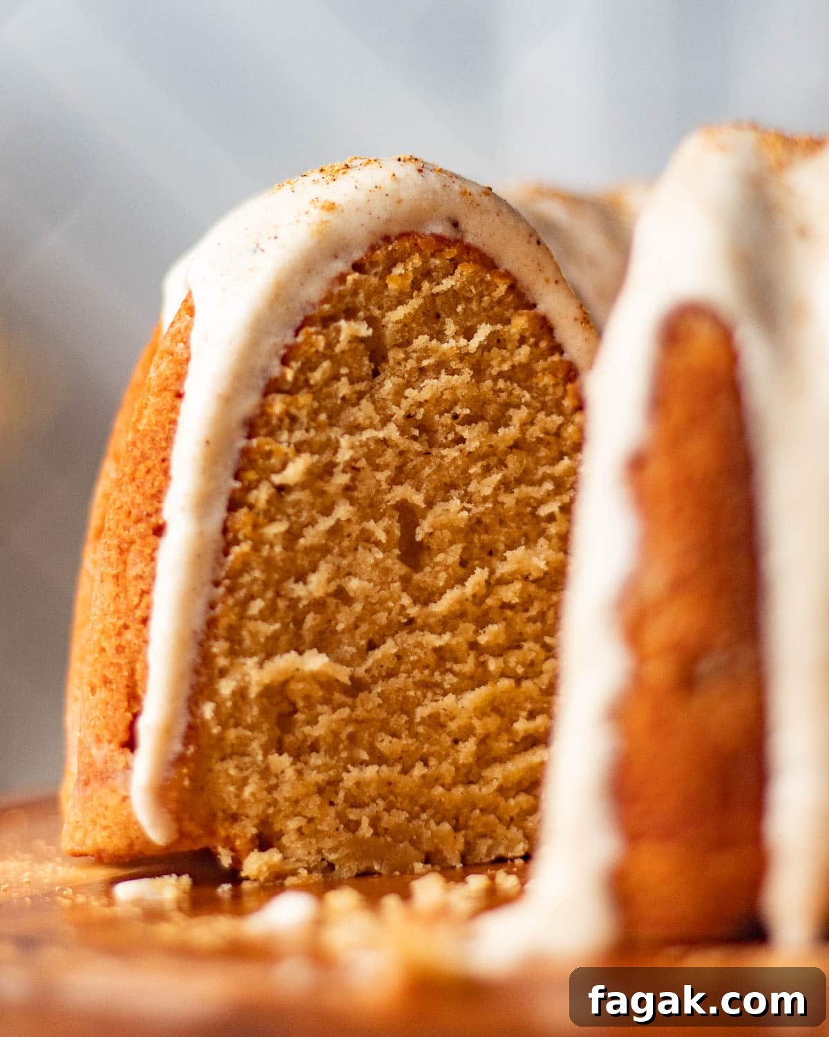 A close-up of the chai cake's interior, showing the moist, spiced texture of the bundt spice cake, topped with a thick layer of cream cheese frosting.