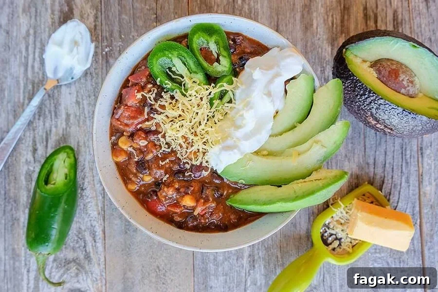 black bean chili topped with avocado and sour cream in a bowl