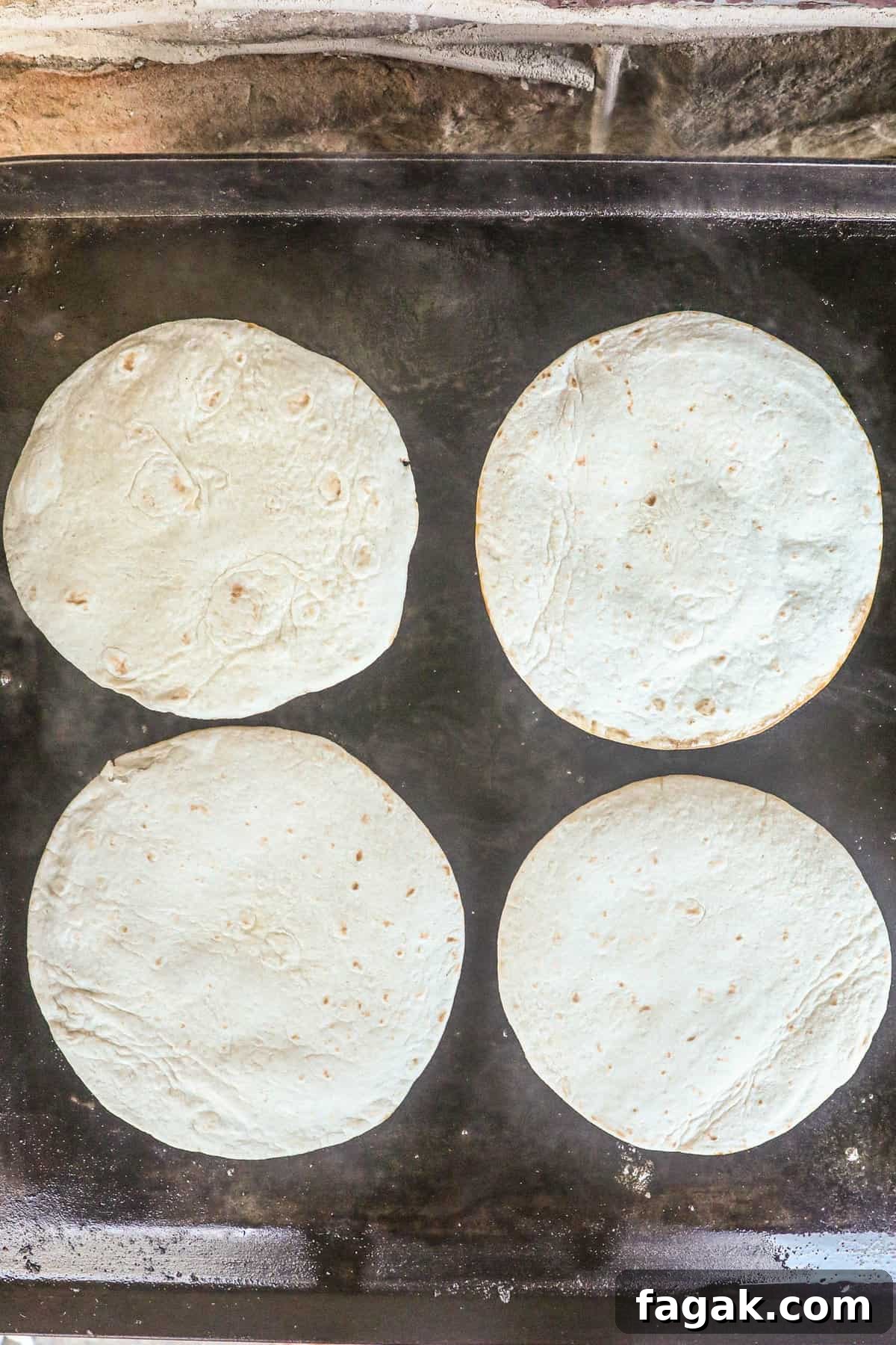 Beef and tortillas face down on buttered Blackstone griddle for Smash Burger Tacos