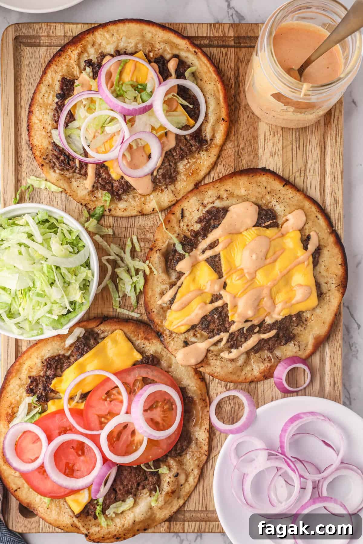 Smash Burger Tacos on Cutting Board with the fixings and burger sauce
