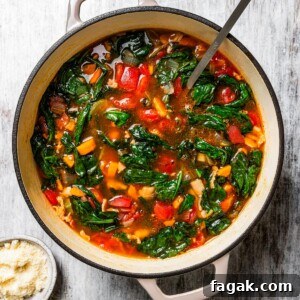 Finished minestrone soup in a large pot with a ladle, surrounded by soup ingredients.