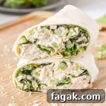 caesar chicken salad lunch wraps cut in half on a cutting board.