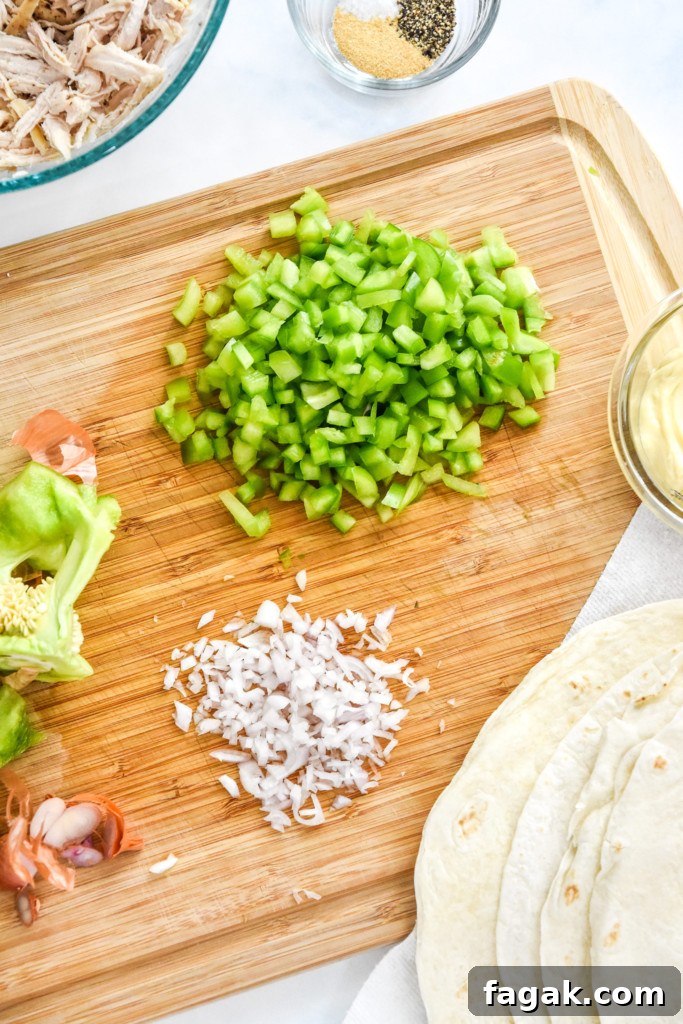 chopping green bell peppers and shallots for the caesar chicken salad.