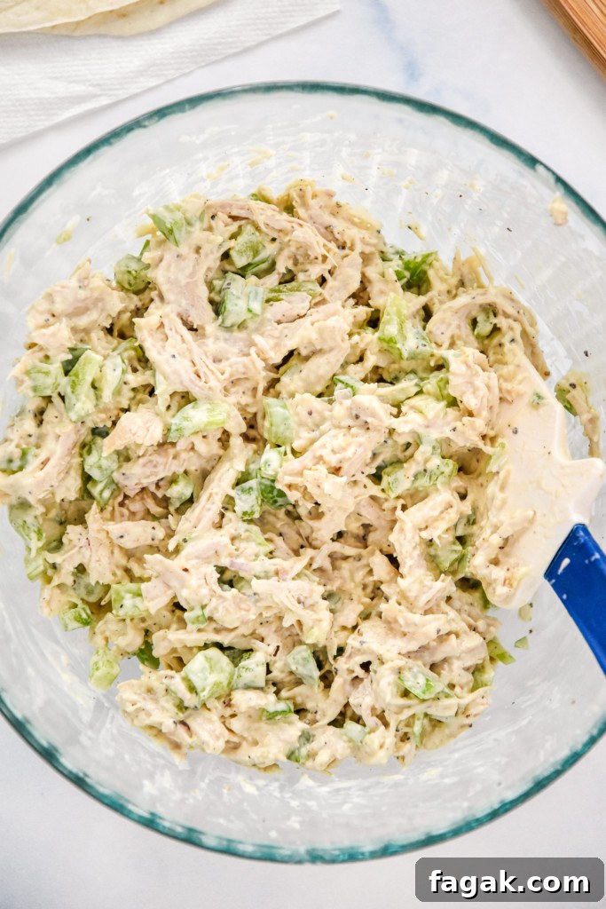 mixed up caesar chicken salad lunch wraps in a glass bowl.