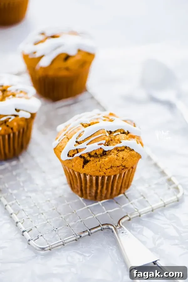 Gluten Free Sweet Potato Muffins on a wire rack topped with a drizzle of marshmallow glaze