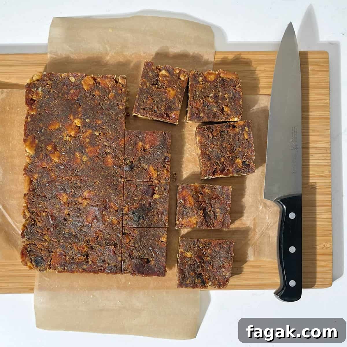 Sliced date squares on a wooden chopping board.