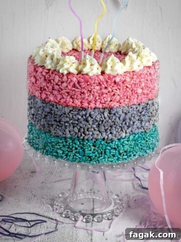 A three layered Rice Krispie cake on a cake stand, surrounded by balloons.