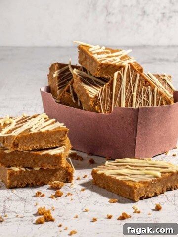 Biscoff slices in a pink carton box with a few slices in the foreground.