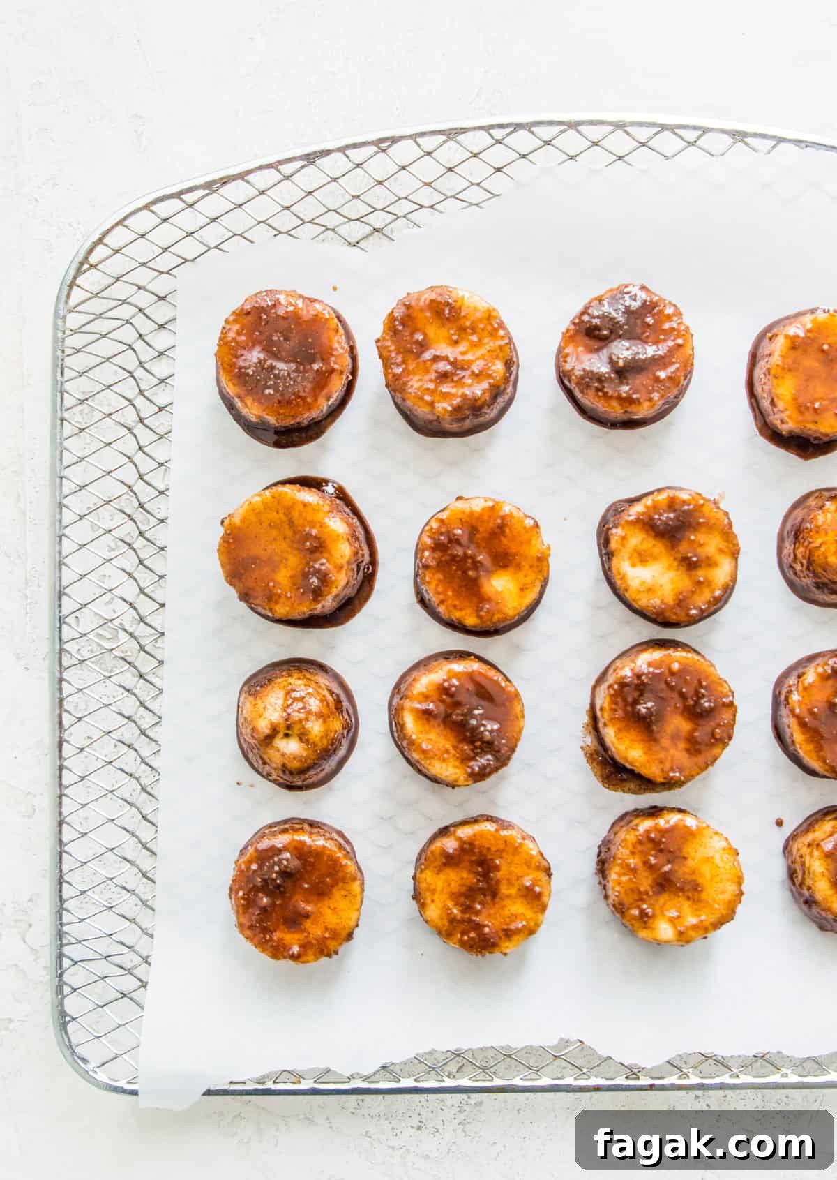 Caramelized Cinnamon Bananas in the Air Fryer 7 Banana slices coated in a cinnamon sugar mixture on an air fryer tray.