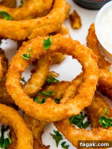 A plate of cooked onion rings garnished with fresh parsley.