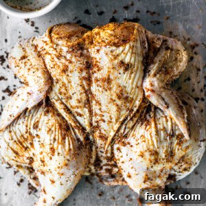 Spatchcocked chicken on a baking sheet.