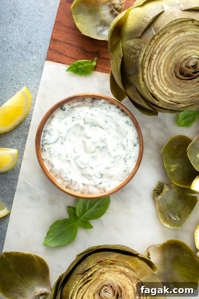 Top view of artichoke dipping sauce in a wooden bowl over a marble board