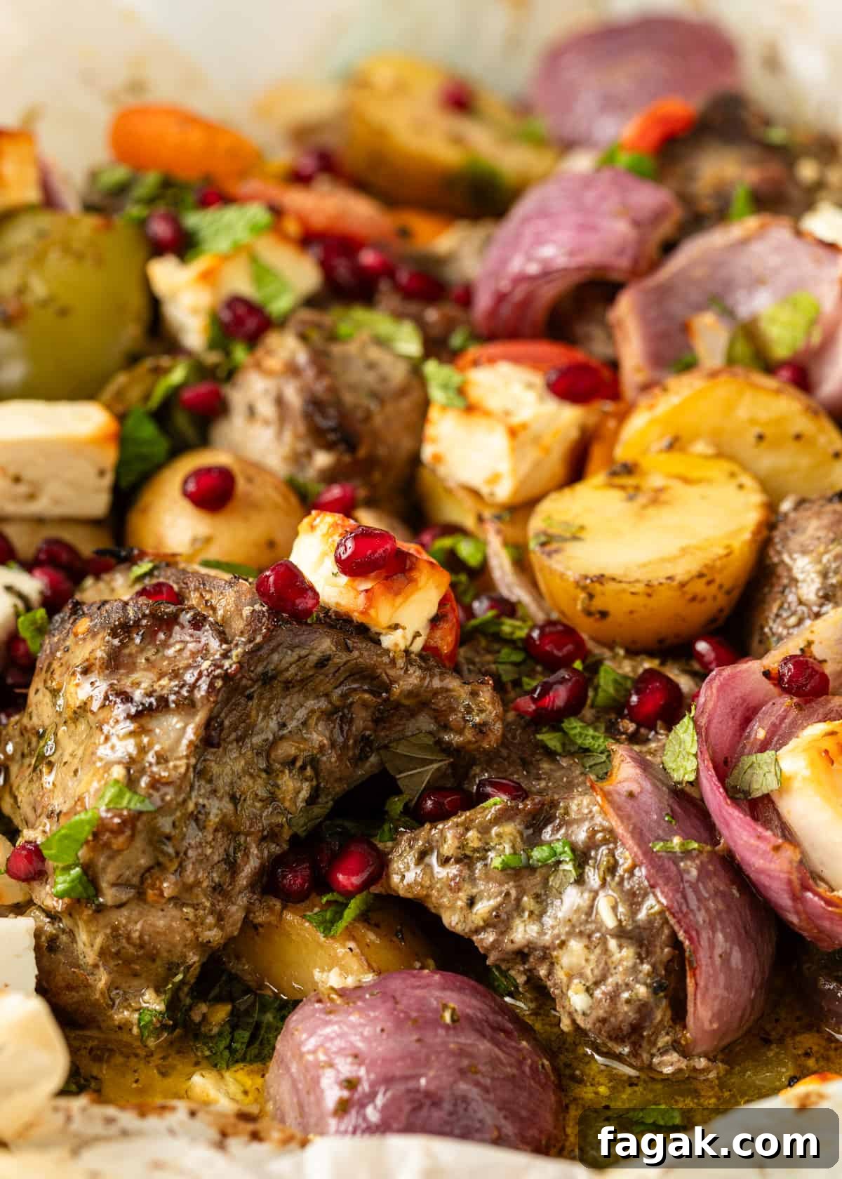 closeup: lamb in parchment after roasting with pomegranate seeds and fresh parsley on top