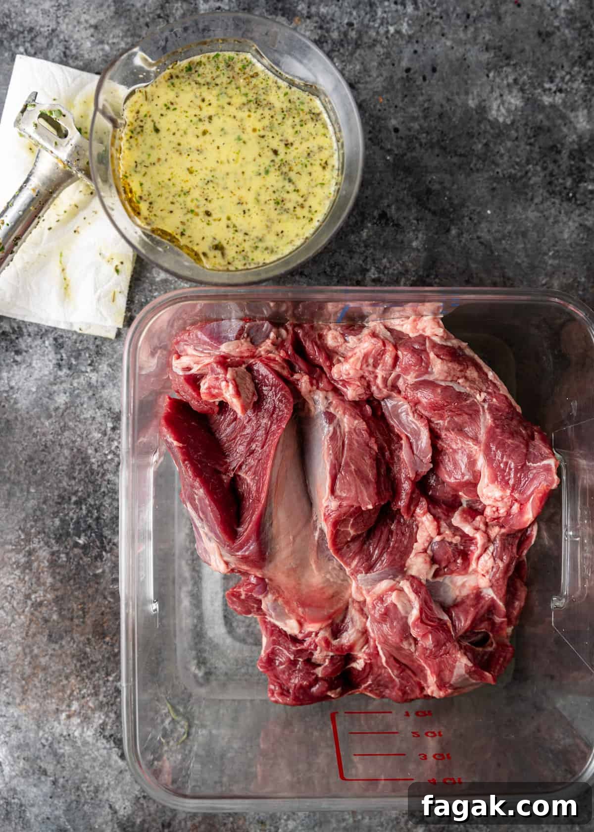 overhead: Greek lamb in a plastic measuring bowl with marinade to the side