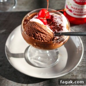 Coconut mousse with chocolate served in a glass cup.
