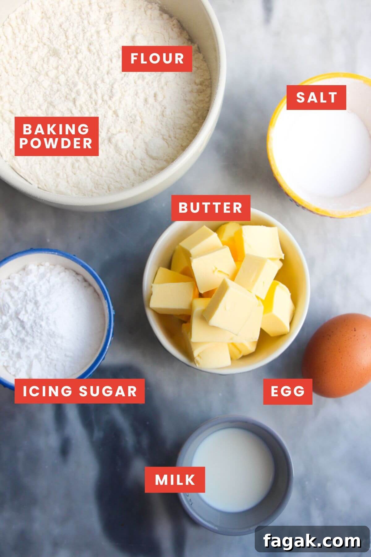 Ingredients for pastry laid out on a grey marble background and labelled.