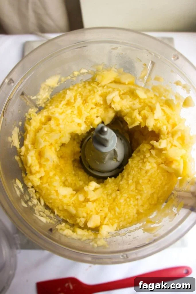 Blitzed up apples in the bowl of a food processor.