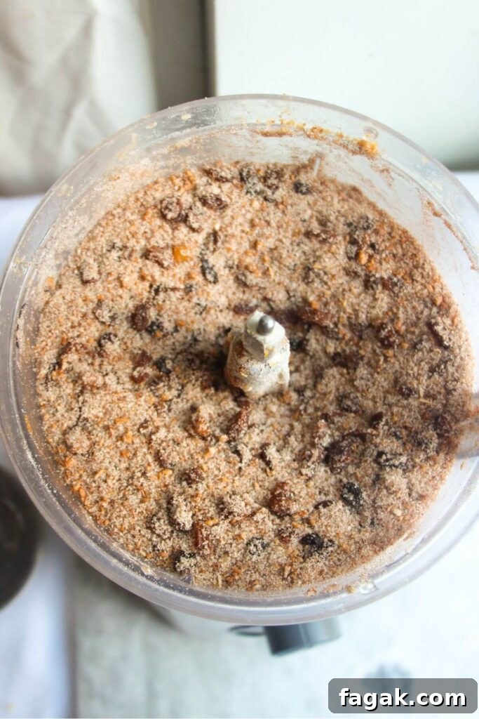 Dried fruit and sugar in the bowl of a food processor.