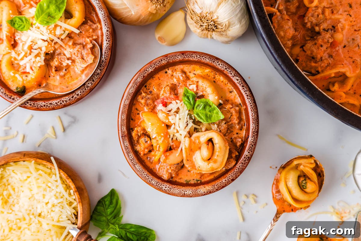 Two bowls filled with tomato tortellini soup.
