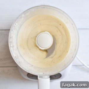 Whipped mayo in a food processor on a white board
