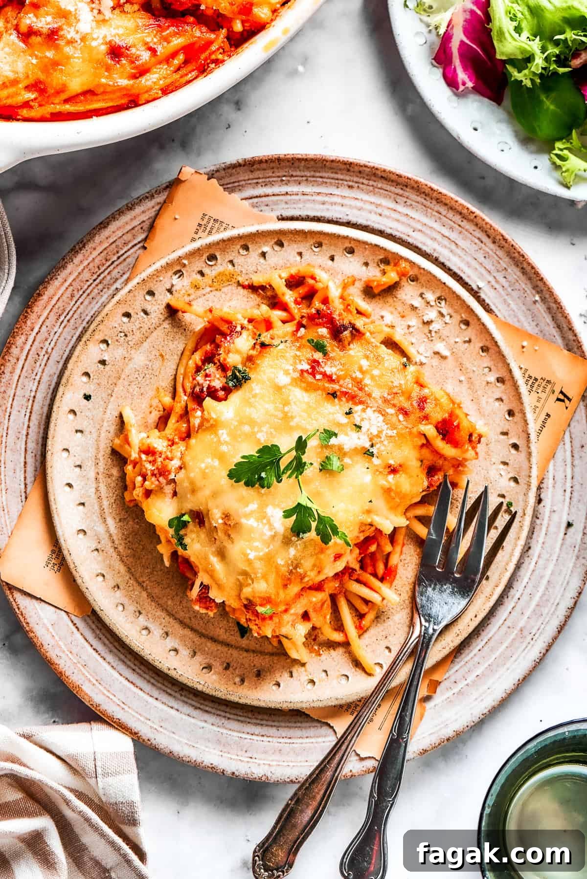 A serving of million dollar spaghetti served on a plate with forks.