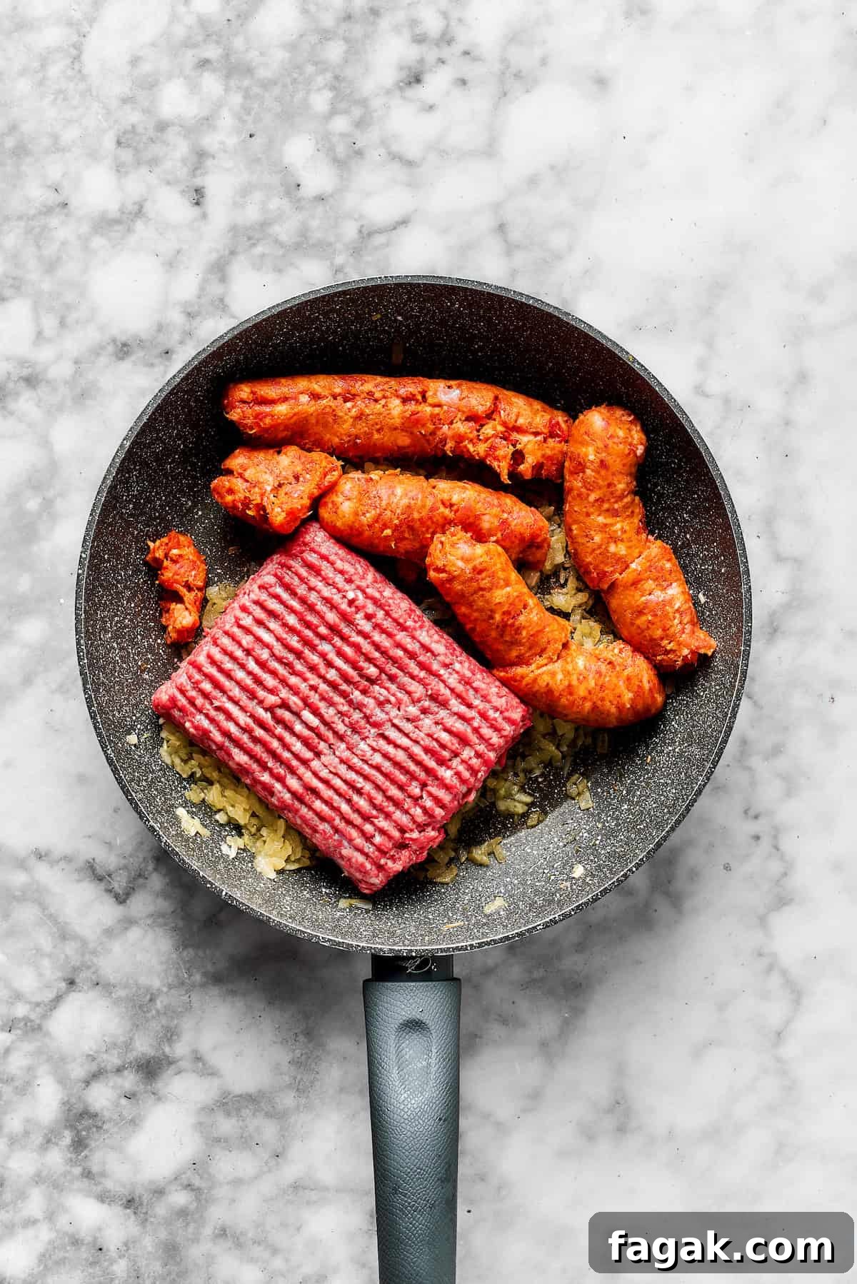 Adding ground beef and sausage to the skillet.