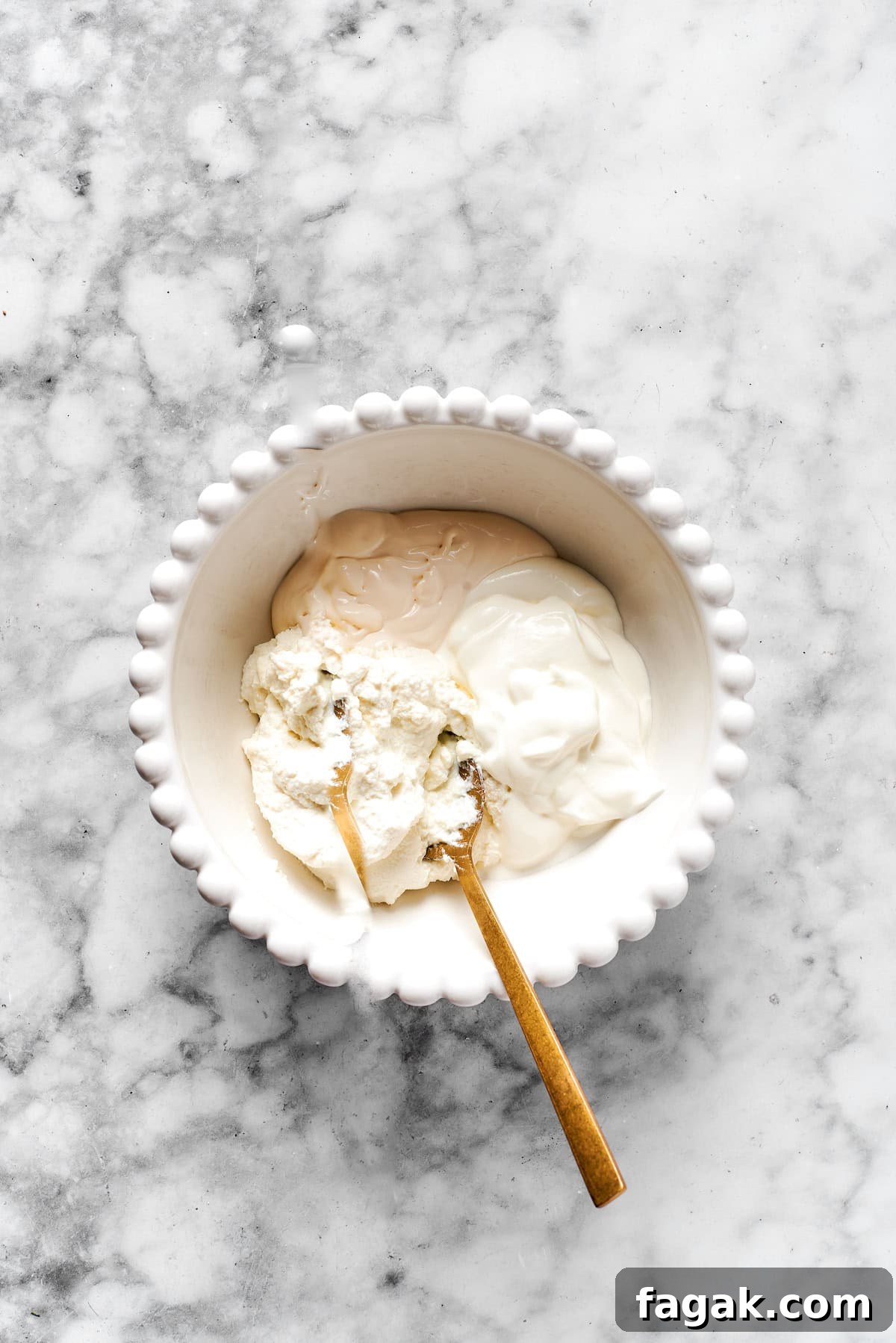 Added cheese mixture ingredients to a white bowl. 