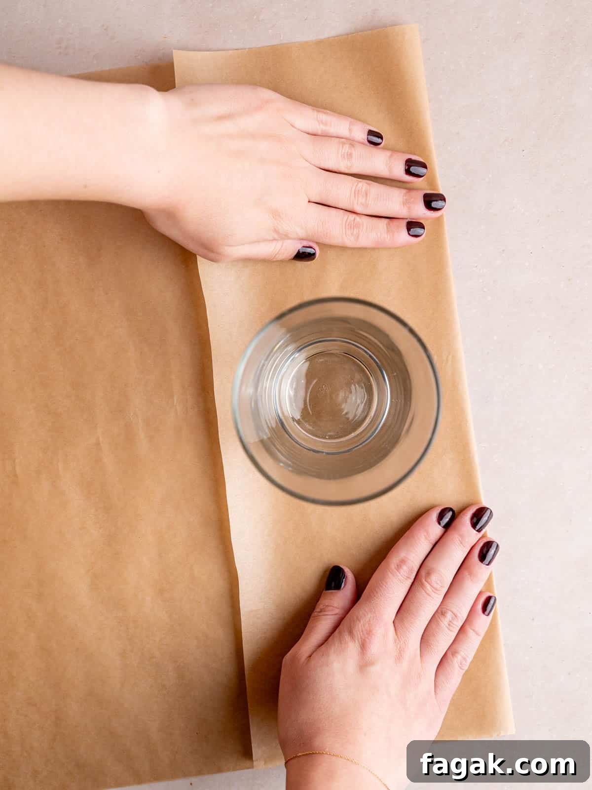 A pint glass sitting on top of a folded piece of parchment paper.