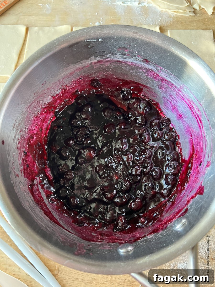 A saucepan of cooked blueberry hand pie filling.