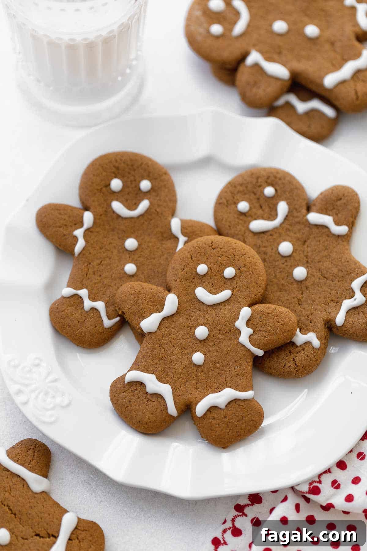 gluten free gingerbread cookies on white plate with glass of milk.