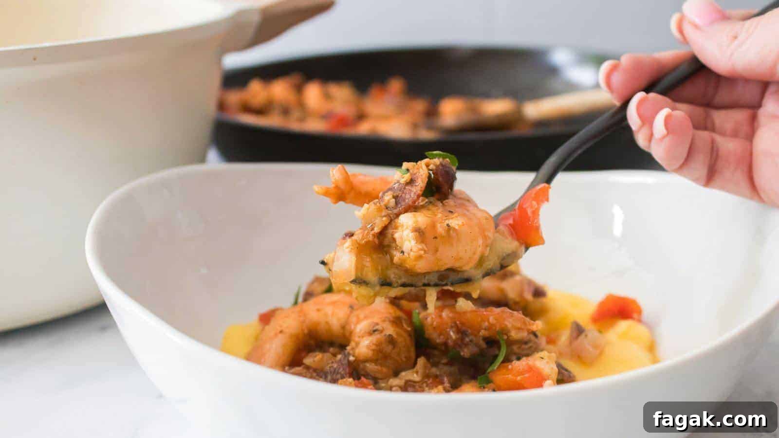 16 Light and Satisfying Shrimp Recipes for Quick Weeknight Meals 18 A hand holding a fork with seasoned shrimp over a bowl of polenta. A pan with more shrimp is in the background.
