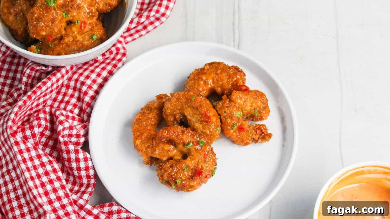 16 Light and Satisfying Shrimp Recipes for Quick Weeknight Meals 7 Fried shrimp on a plate next to a bowl of sauce.