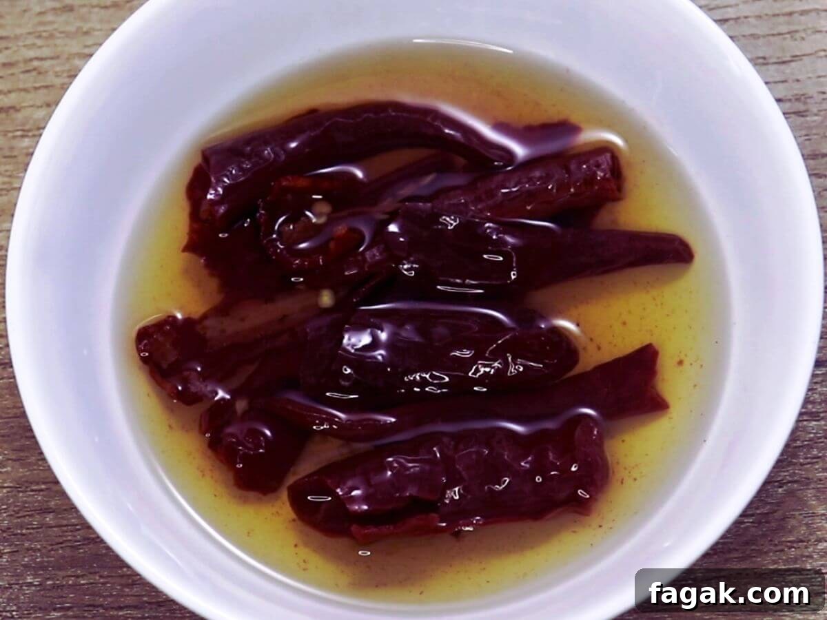 image showing soaking red chillies in ot water in a small bowl.