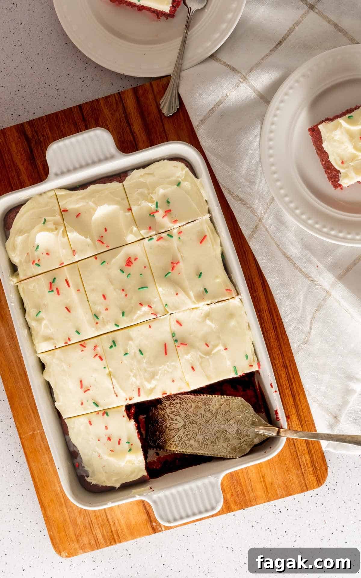 Birds eye view of red velvet poke cake frosted and sliced into squares.