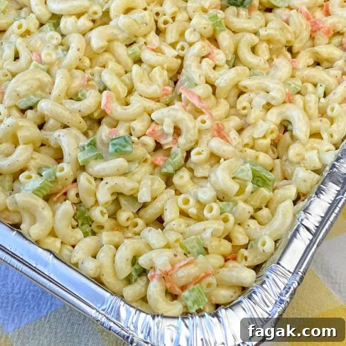 Dish full of creamy and delicious macaroni salad recipe for a crowd on a yellow and white napkin