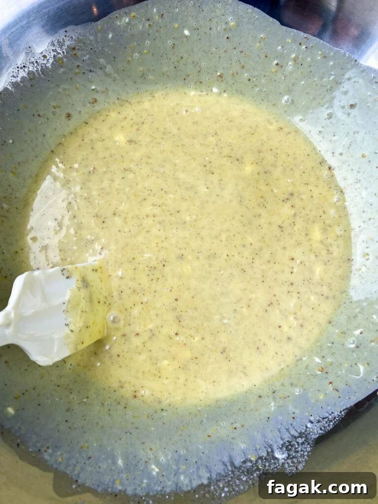 Spatula in large mixing bowl stirring dressing