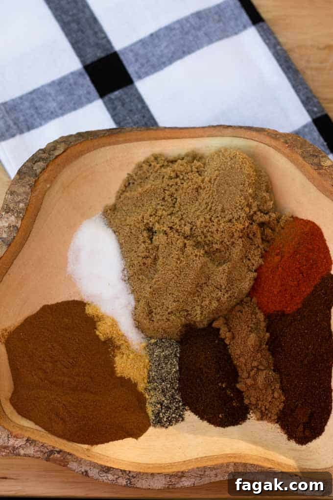 many spices laid next to each other in wooden bowl laying on plaid towel