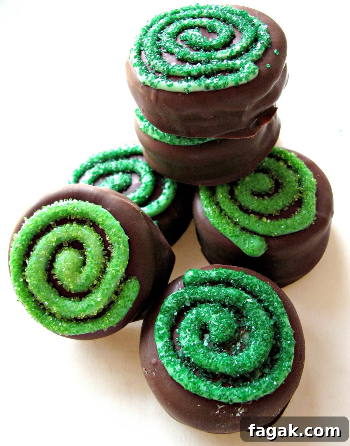 Chocolate Covered Oreos with a green sparkle sugar coated swirl on top.