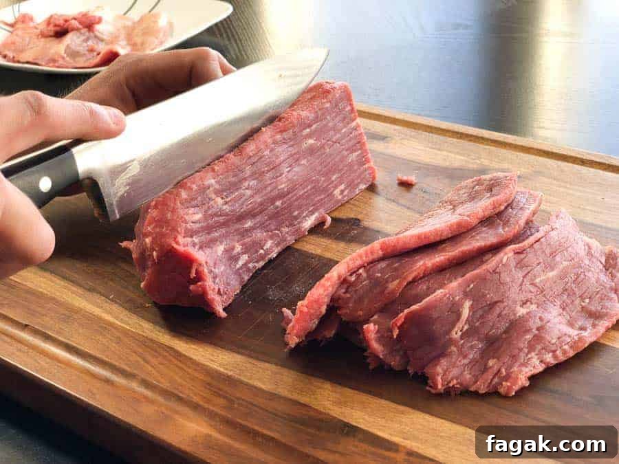Eye of round beef roast being sliced in cutting board