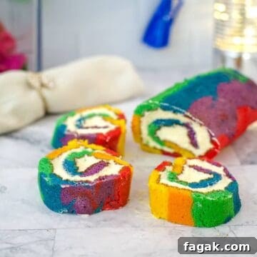 Three slices of a colorful rainbow cake roll with swirls of cream filling are arranged on a marble surface alongside the remaining unsliced roll.