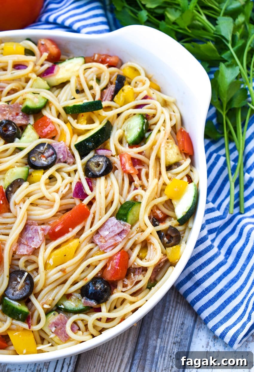 Italian summer spaghetti salad in a large white serving bowl