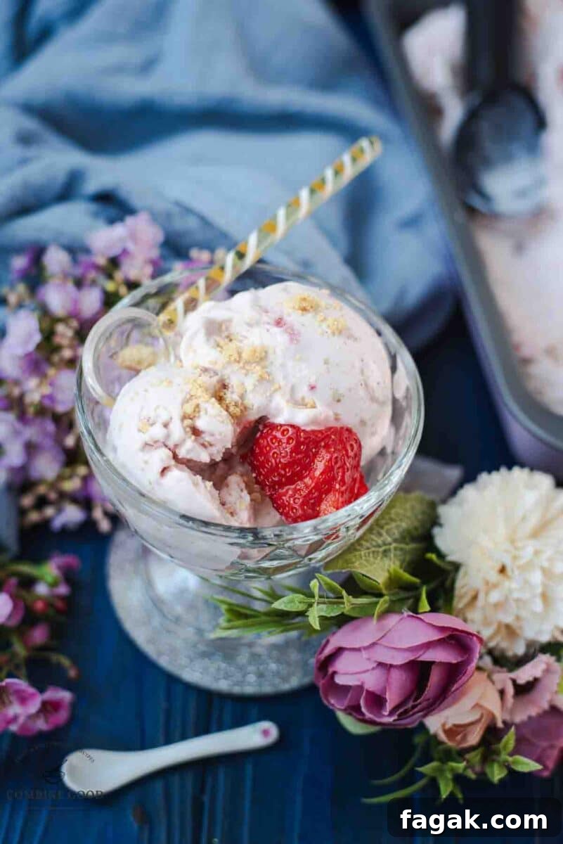 Glass serving bowl, filled with delicious strawberry shortcake ice cream. Garnished with fresh strawberries and shortbread cookie crumbs.