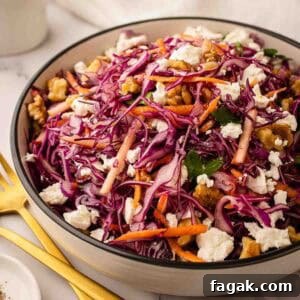 Red Cabbage Salad with red cabbage, grated carrot topped with feta in a round serving bowl.