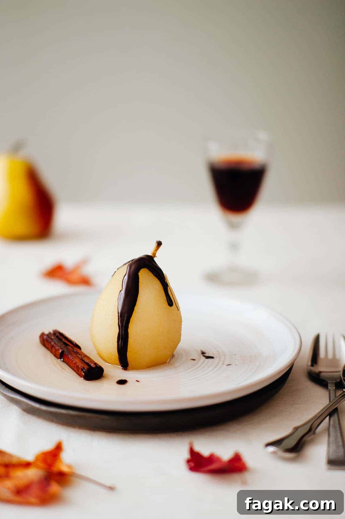 a poached pear on a plate drizzled with chocolate 