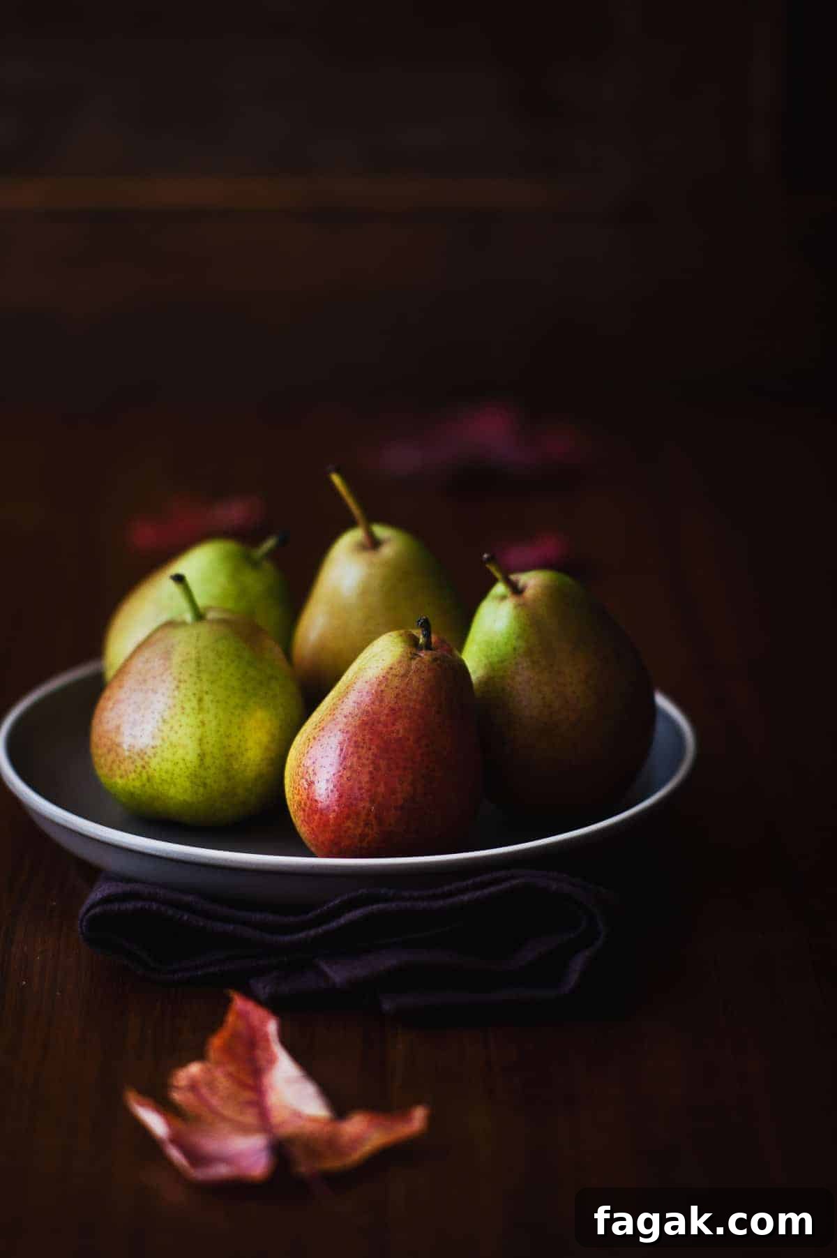 five pears on a grey plate
