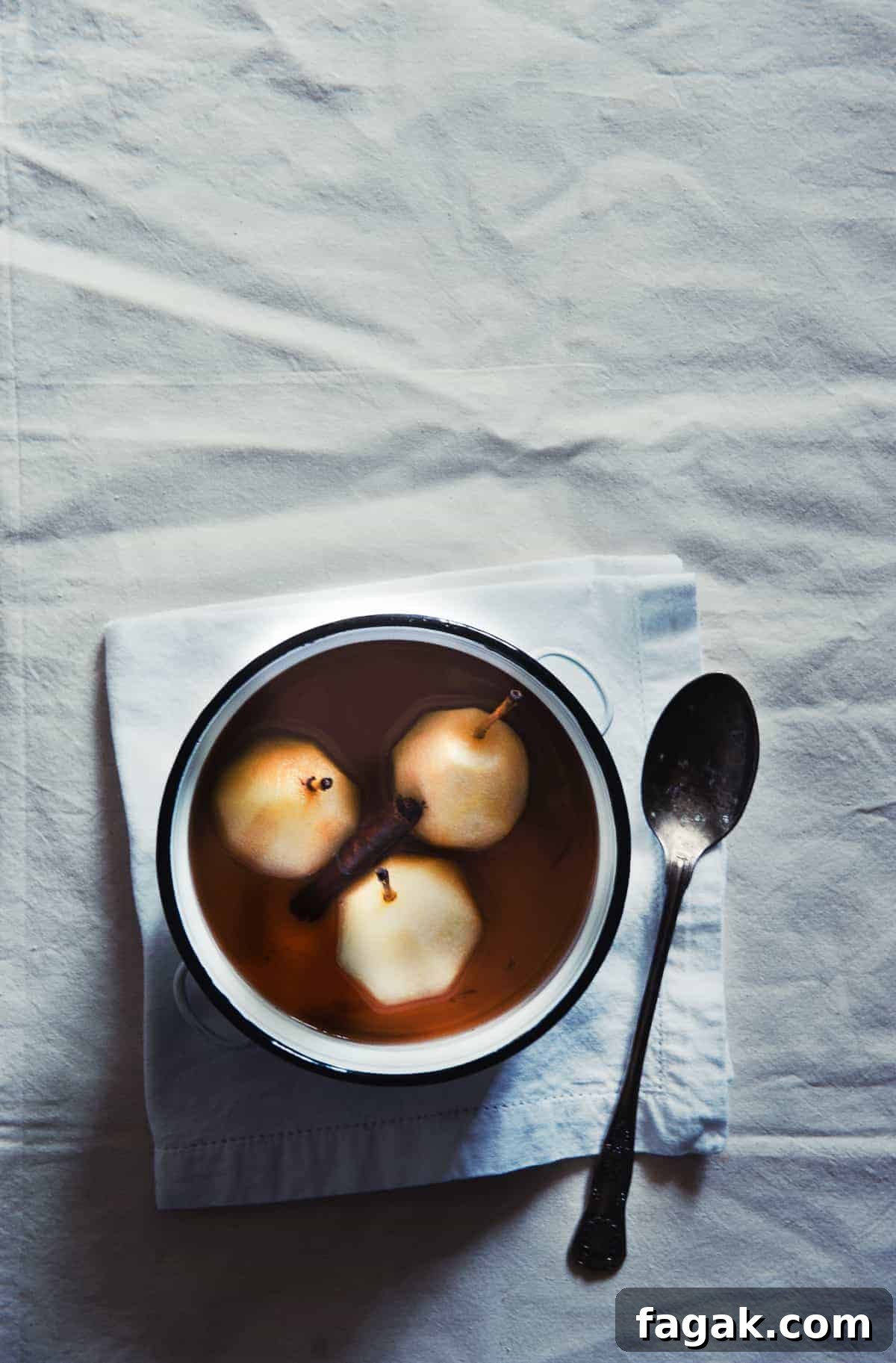 three poached pears in a white pot