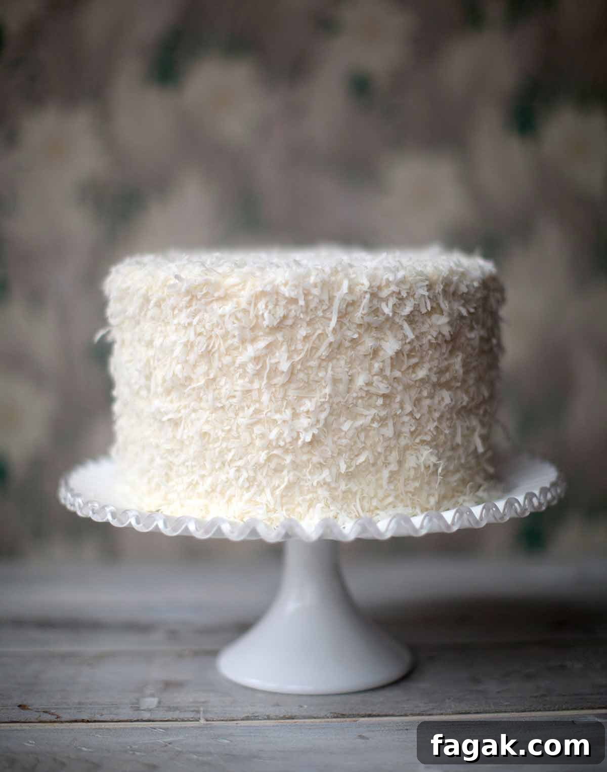 A Brown Betty Bakery coconut cake on a decorative white cake stand.