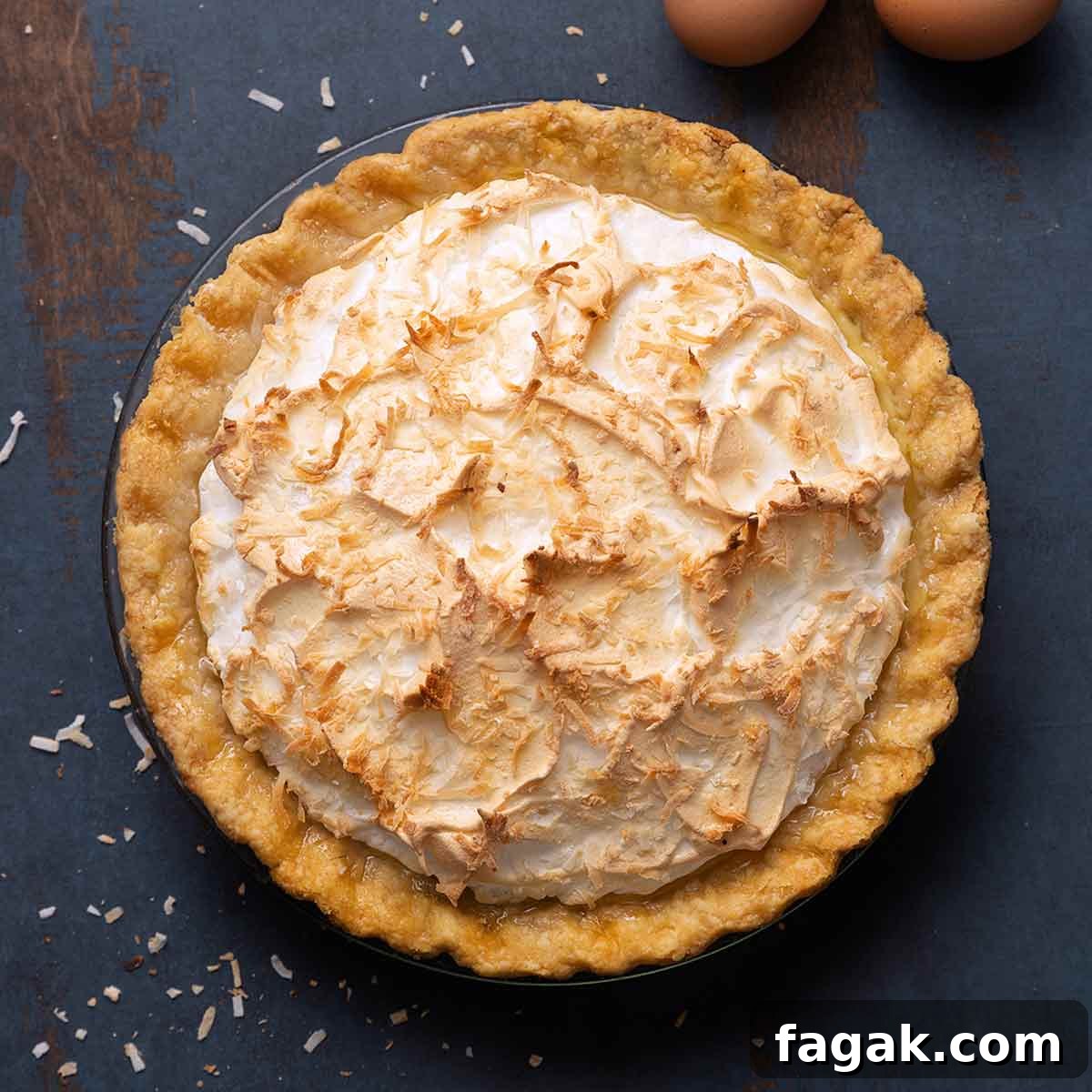 A coconut cream pie with a meringue top and sprinkled with toasted shredded coconut.