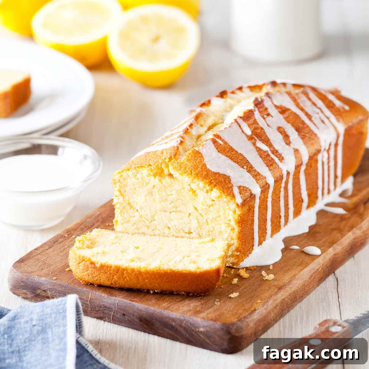 Ina Garten's lemon cake, a pound cake, on a cutting board, drizzled with a lemon glaze